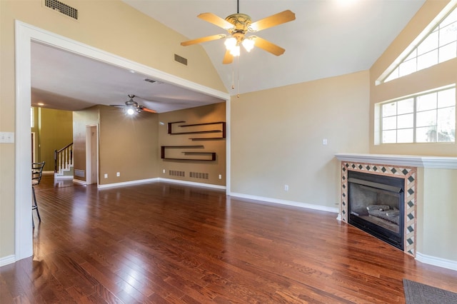 unfurnished living room featuring high vaulted ceiling, dark wood-type flooring, ceiling fan, and a fireplace