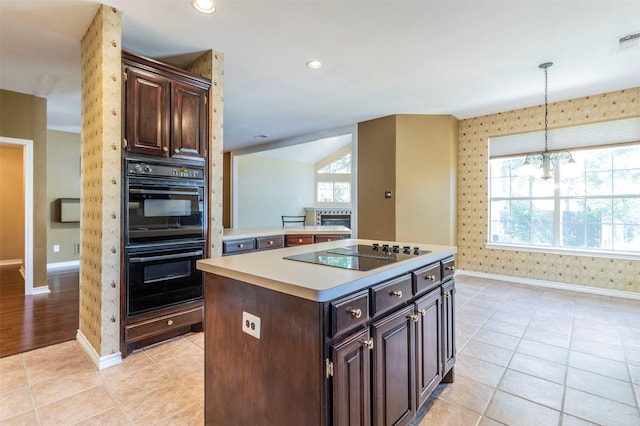 kitchen featuring dark brown cabinets, pendant lighting, light tile patterned floors, a center island, and black appliances