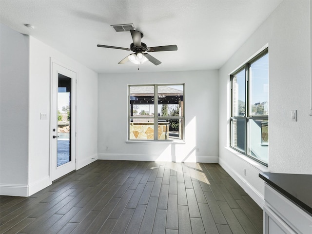 unfurnished room with dark wood-type flooring and ceiling fan