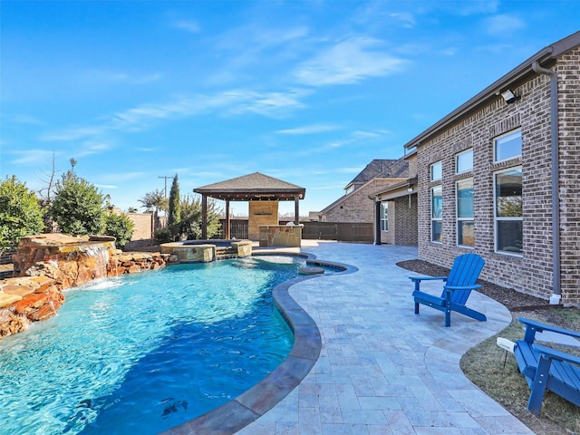 view of pool featuring an in ground hot tub, pool water feature, a patio, and a gazebo