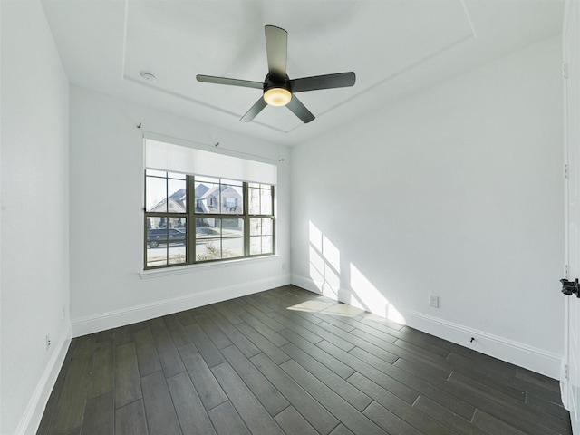 empty room with ceiling fan and dark hardwood / wood-style flooring