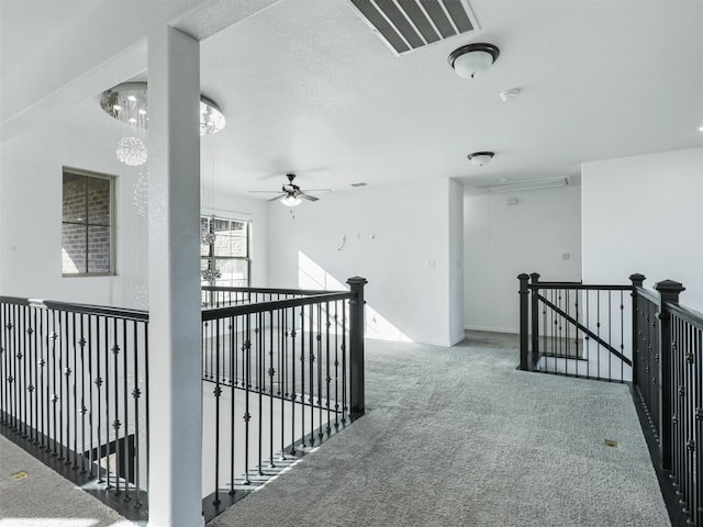 corridor with carpet floors and a textured ceiling