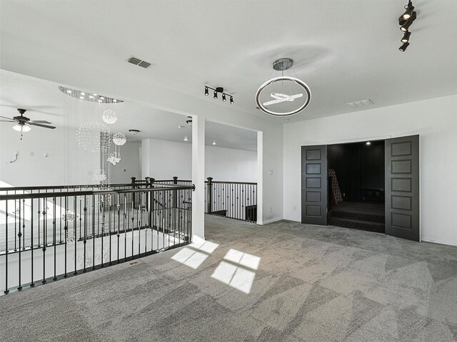 13750 Fernando Rd, Frisco, TX 75035 - carpeted spare room with rail lighting, a ceiling fan, a chandelier, and baseboards