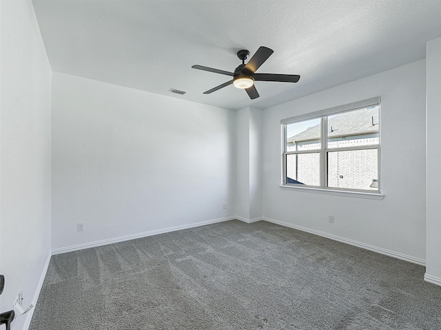 unfurnished room featuring dark colored carpet, a textured ceiling, and ceiling fan