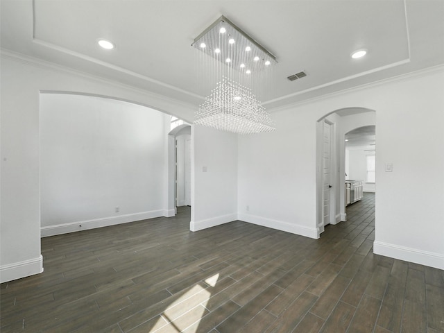 empty room with ornamental molding, dark wood-type flooring, and a notable chandelier