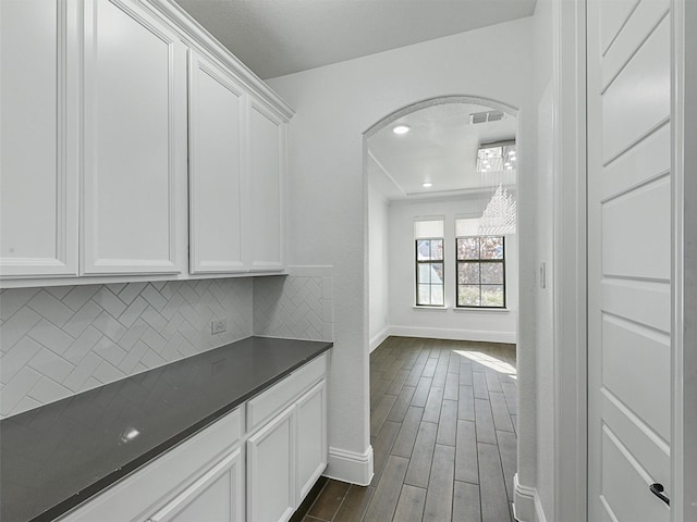 bar featuring tasteful backsplash, white cabinetry, and dark hardwood / wood-style floors