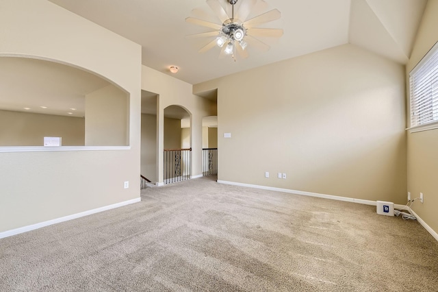 empty room with lofted ceiling, ceiling fan, and carpet flooring