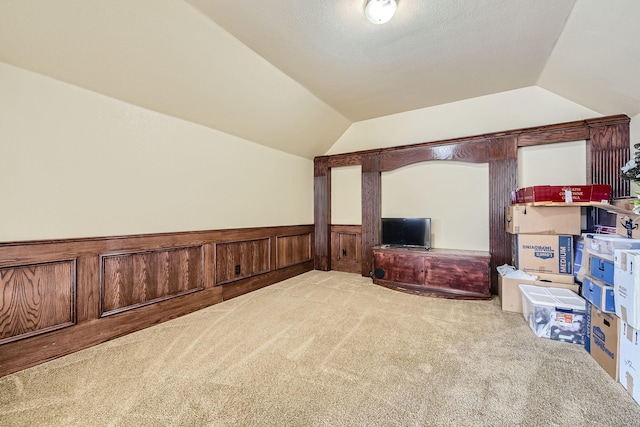 bonus room with vaulted ceiling and light carpet