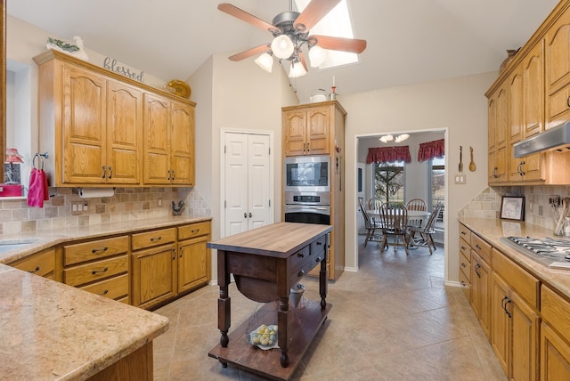 kitchen with lofted ceiling, decorative backsplash, stainless steel appliances, and ceiling fan