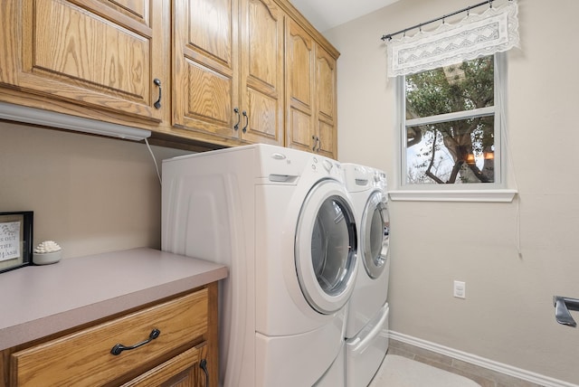 laundry room featuring light tile patterned floors, cabinets, and washer and clothes dryer