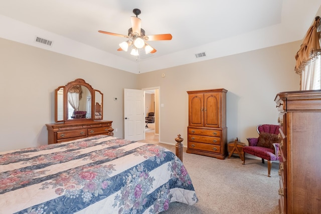 carpeted bedroom featuring ceiling fan and a tray ceiling