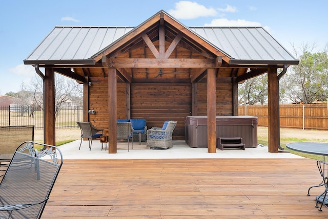 wooden terrace featuring a gazebo, an outdoor hangout area, and a hot tub