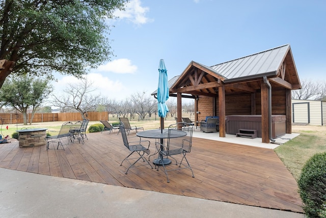 wooden terrace with a hot tub and a fire pit