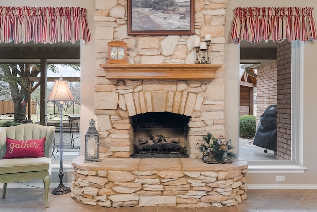 living room featuring a stone fireplace and a wealth of natural light