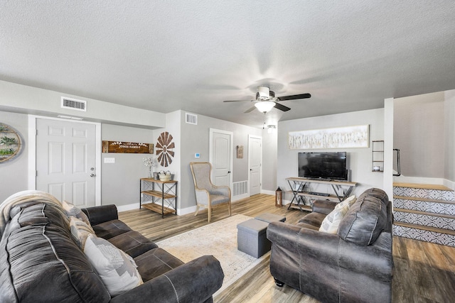 living room featuring hardwood / wood-style flooring, a textured ceiling, and ceiling fan