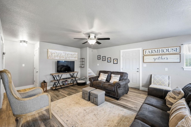 living room featuring ceiling fan, hardwood / wood-style floors, and a textured ceiling