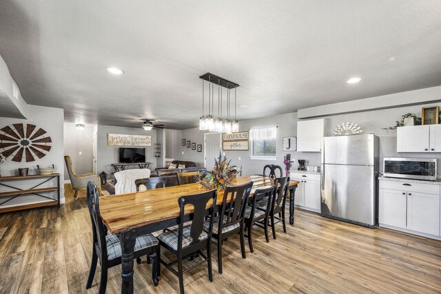 dining room with ceiling fan, a textured ceiling, and light hardwood / wood-style flooring