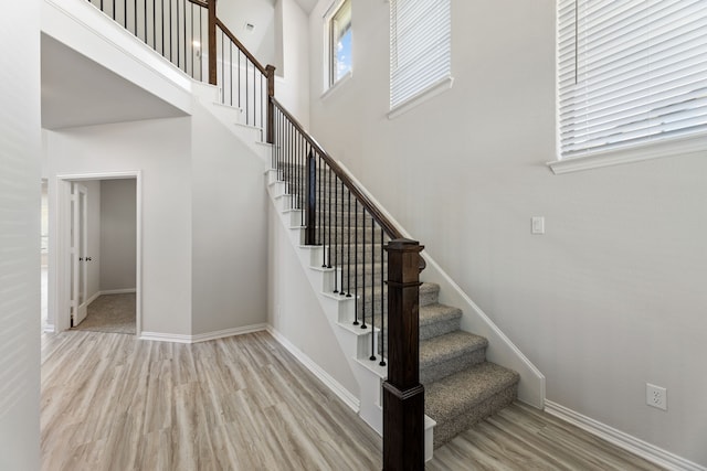 stairs with a high ceiling and wood-type flooring