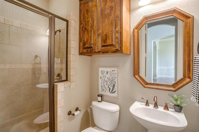 bathroom with sink, an enclosed shower, and toilet