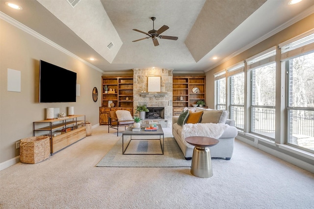 living room featuring built in features, a fireplace, lofted ceiling, a raised ceiling, and crown molding