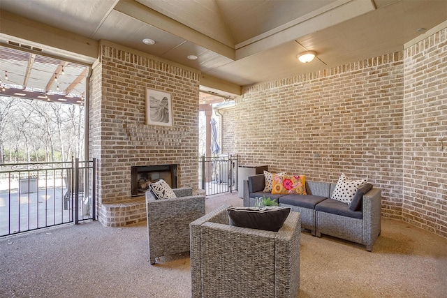 carpeted living room featuring an outdoor brick fireplace, brick wall, and a wealth of natural light