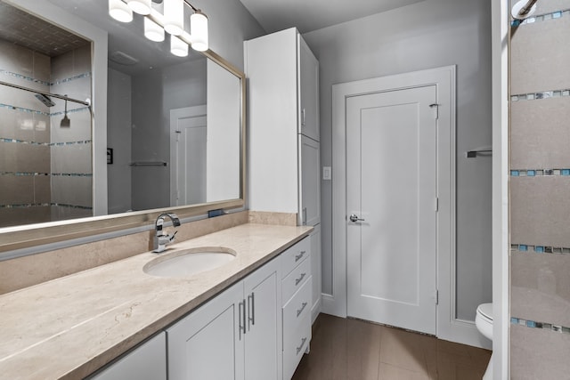 bathroom with vanity, toilet, and a shower