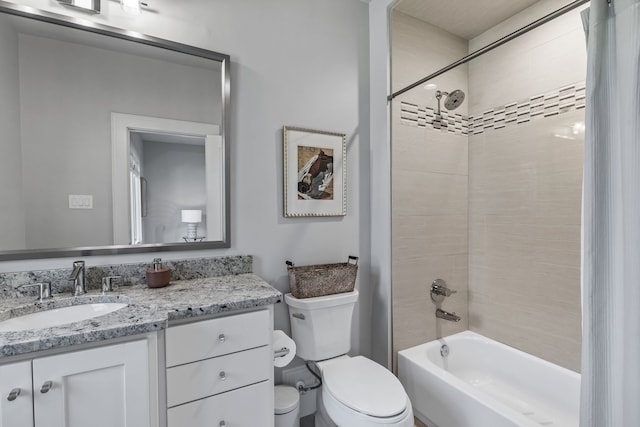 full bathroom featuring tiled shower / bath combo, vanity, and toilet