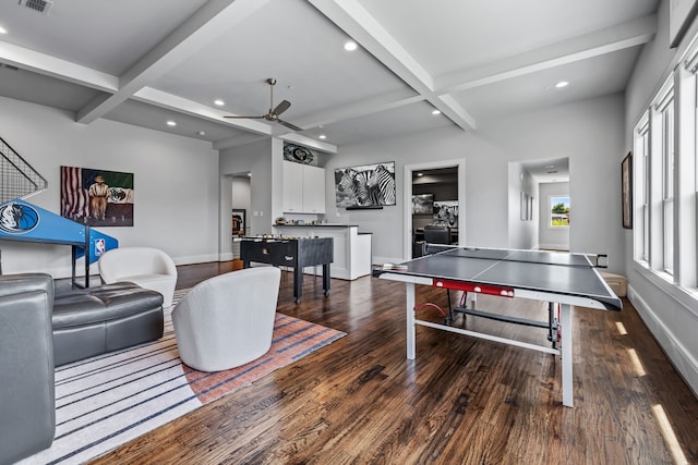 recreation room with ceiling fan, dark wood-type flooring, beamed ceiling, and coffered ceiling