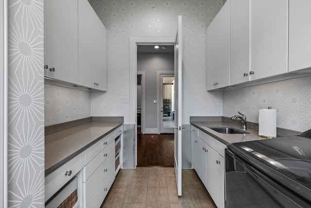 kitchen featuring white cabinets, black electric range, and sink