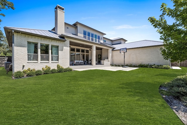 back of house with a patio area and a lawn