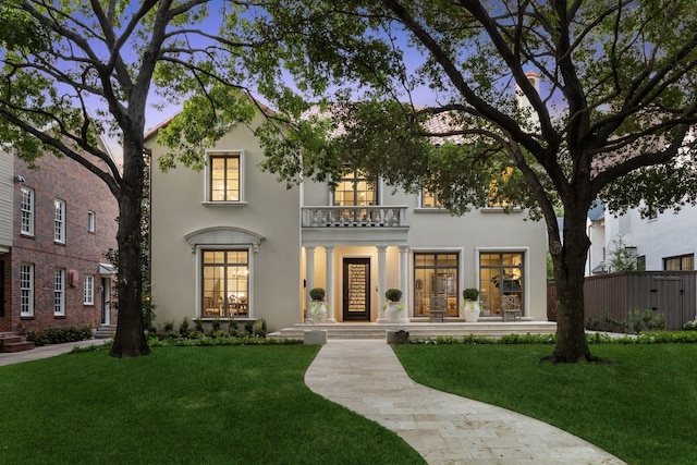 mediterranean / spanish-style home featuring a balcony and a yard