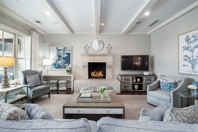 living room featuring beamed ceiling, hardwood / wood-style floors, and a fireplace