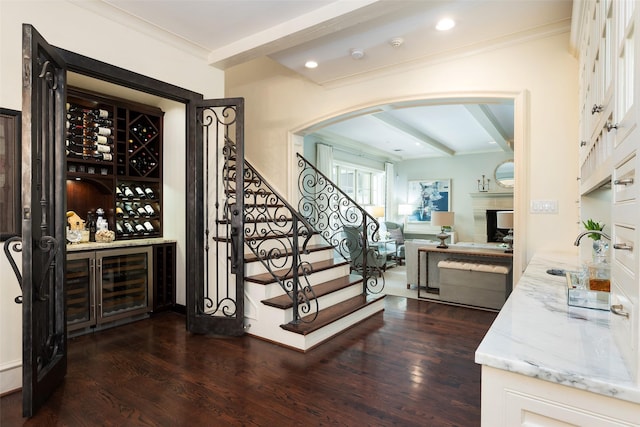 bar with crown molding, white cabinetry, dark hardwood / wood-style floors, and light stone countertops