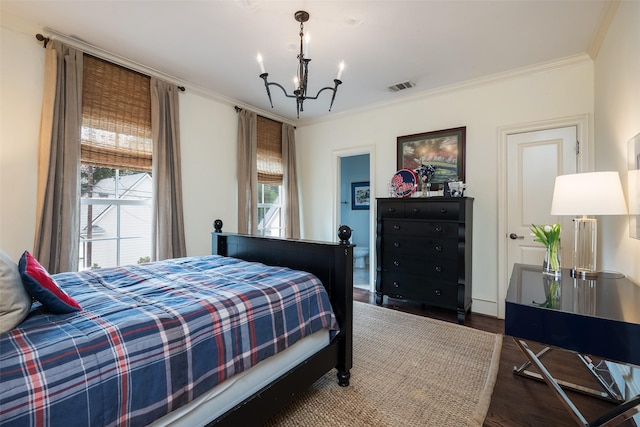 bedroom featuring dark wood-type flooring, a chandelier, and ornamental molding