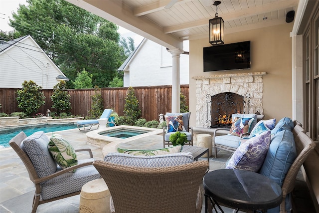 view of patio / terrace featuring a swimming pool with hot tub and an outdoor stone fireplace