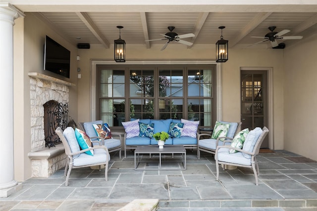 view of patio featuring ceiling fan and an outdoor living space with a fireplace