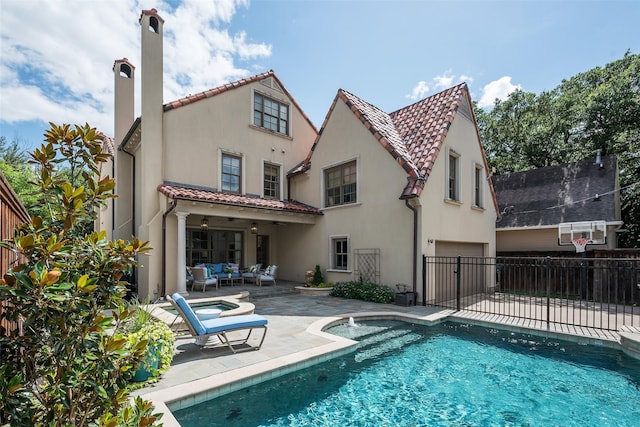 rear view of property featuring an outdoor living space, a fenced in pool, and a patio area