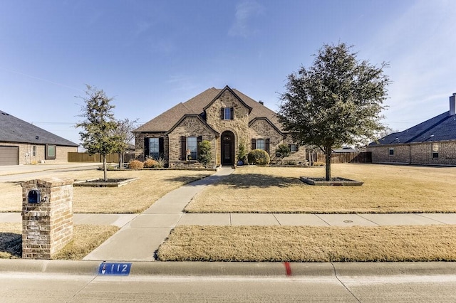 french country inspired facade with a front lawn