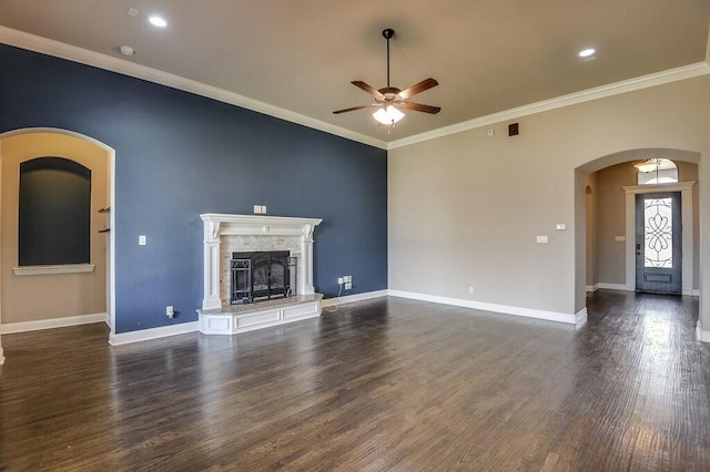 unfurnished living room featuring ceiling fan, ornamental molding, dark hardwood / wood-style floors, and a tile fireplace