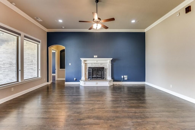 unfurnished living room with ceiling fan, ornamental molding, and dark wood-type flooring