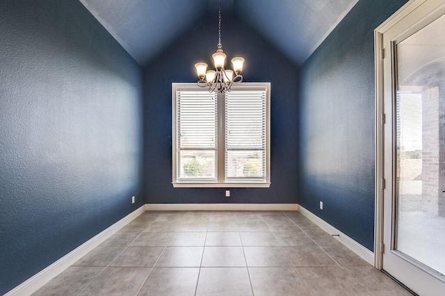 tiled empty room with lofted ceiling and a notable chandelier