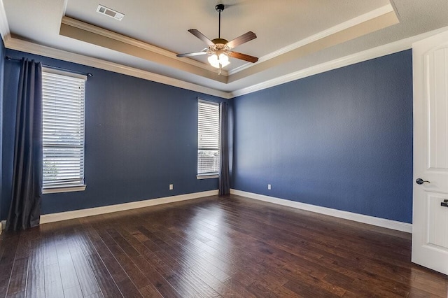 unfurnished room with ceiling fan, a raised ceiling, ornamental molding, and dark hardwood / wood-style floors