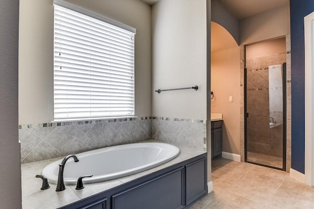 bathroom with tile patterned flooring, shower with separate bathtub, and vanity