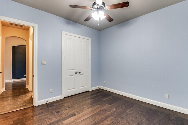 unfurnished bedroom with dark hardwood / wood-style floors, a closet, and ceiling fan