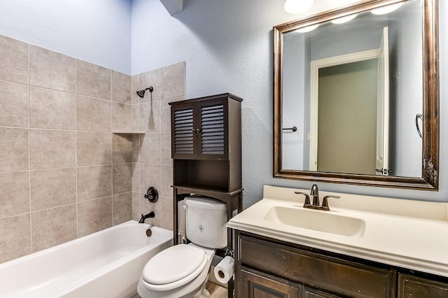 full bathroom featuring tiled shower / bath combo, vanity, and toilet