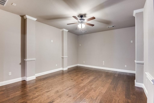 empty room with ceiling fan, hardwood / wood-style floors, and ornate columns