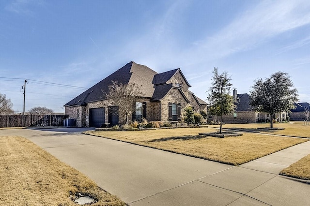 french country inspired facade featuring a garage and a front lawn