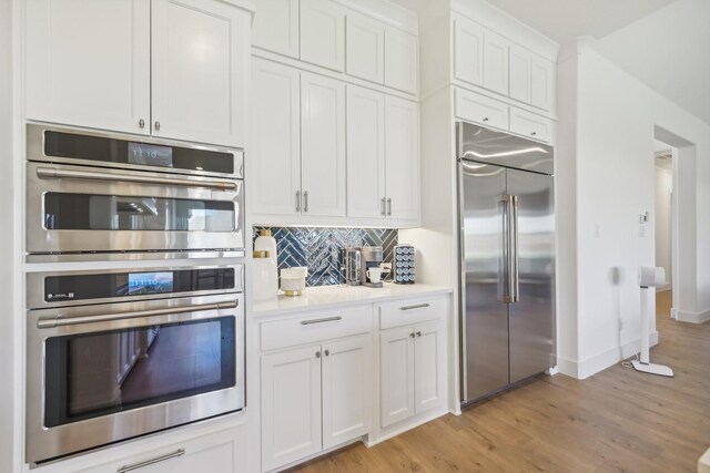 kitchen featuring decorative light fixtures, sink, and white cabinetry