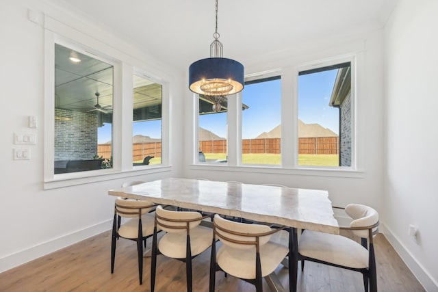 dining area with an inviting chandelier, baseboards, breakfast area, and wood finished floors