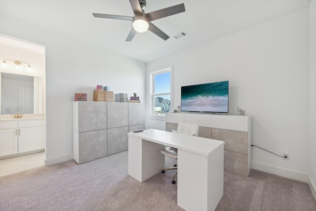 office area featuring light carpet, baseboards, visible vents, and a ceiling fan